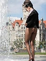 Business lady in pantyhose bathed in town fountain